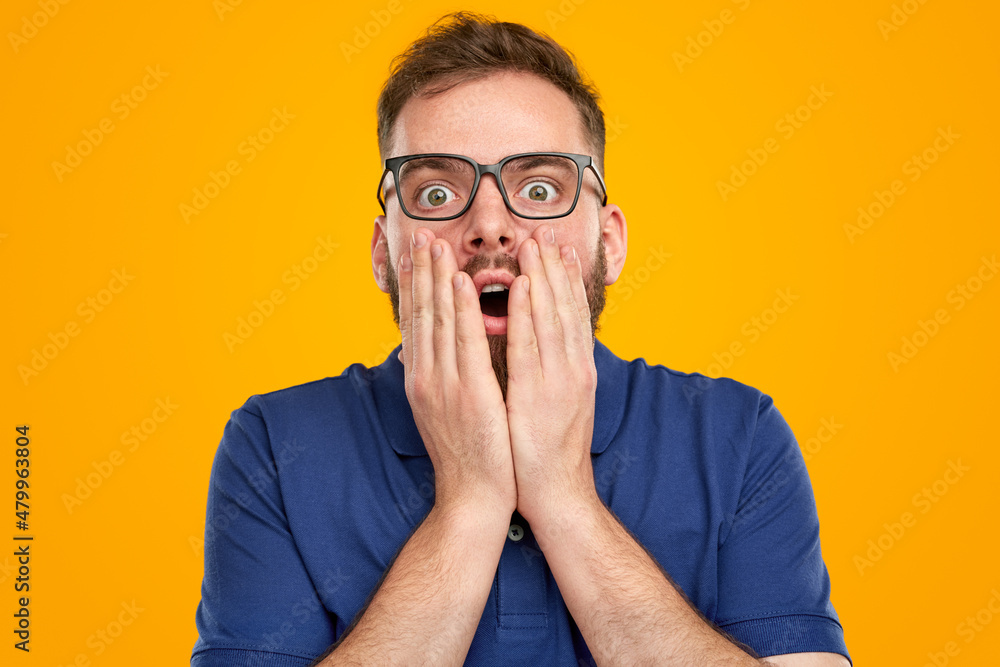 Shocked man touching face in studio Shocked man touching face in studio