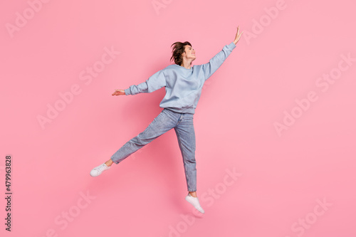Full size photo of cool millennial lady run wear pullover jeans sneakers isolated on pink background