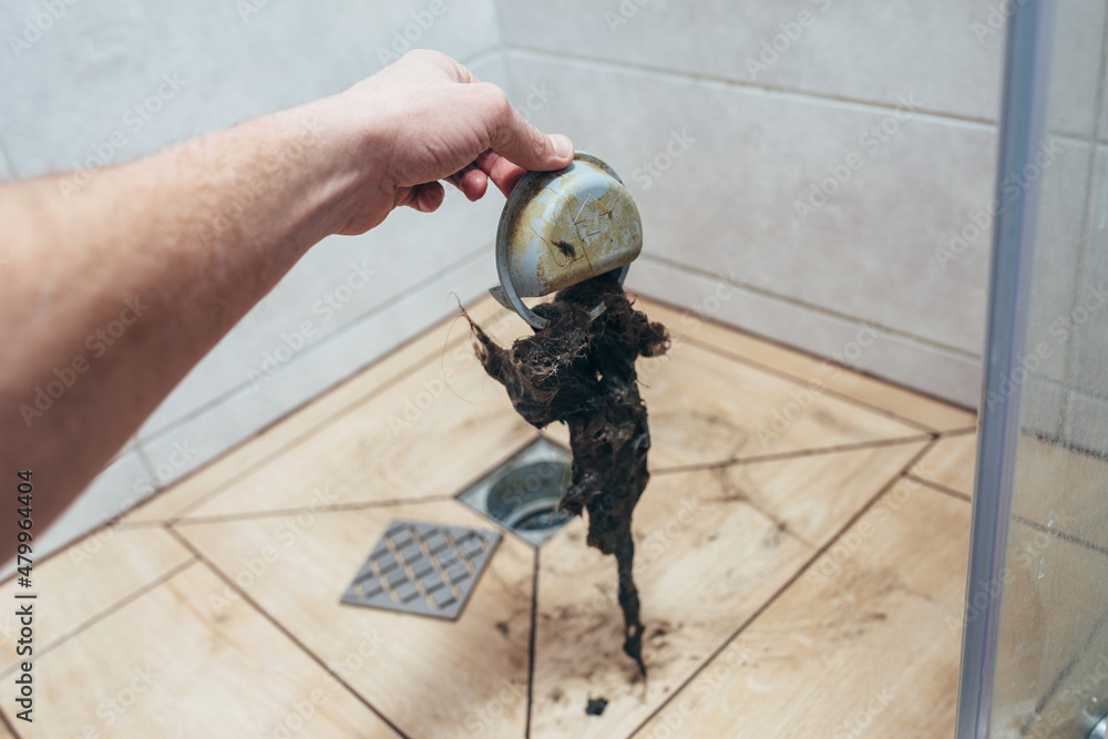 Water drain is clogged with hair. Close-up of drain. Water drain is clogged with hair. Close-up of drain.