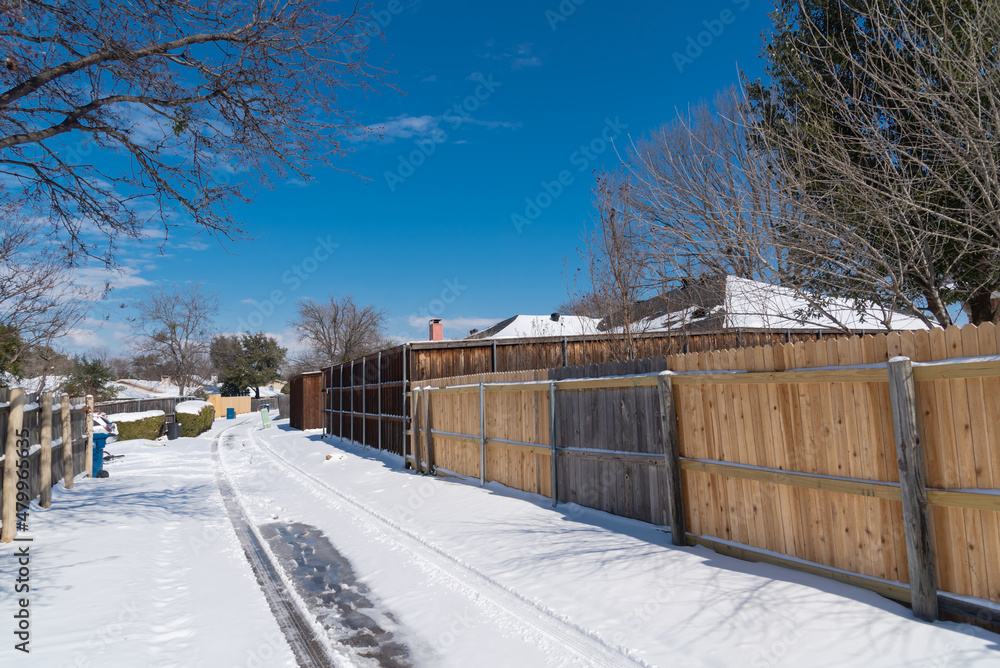 Snow covered the back alley of residential houses roofs and wooden fence after the historic blizzard near Dallas, Texas, USA Snow covered the back alley of residential houses roofs and wooden fence after the historic blizzard near Dallas, Texas, USA