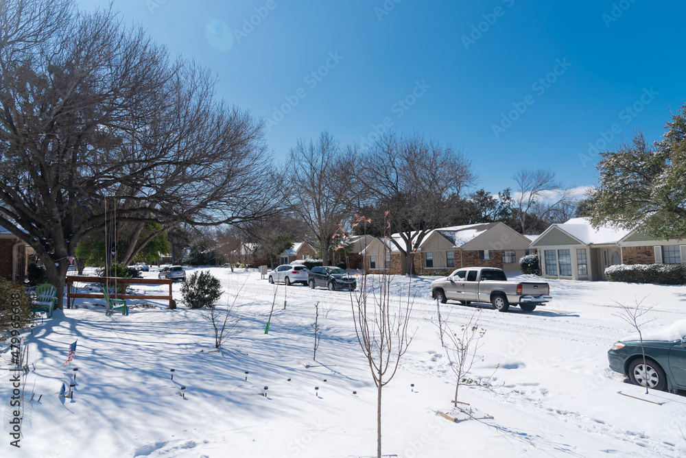 View from front yard of suburban house under snow cover after historic blizzard near Dallas, Texas, USA