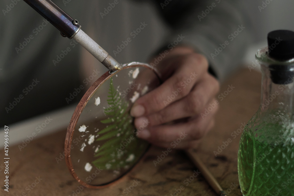 Fotka „Stained glass maker works with colorful souvenirs. Female hands