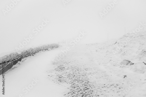 Winter road uphill in bad weather. Winter landscape.
