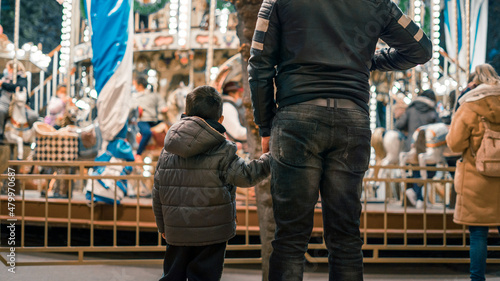 Father and son watch a carousel