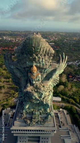 Vertical drone video of Garuda Wisnu Kencana (GWK) at Umalas, Nusa Dua, Bali, Indonesia at sunset. This is the largest statue in Indonesia. photo