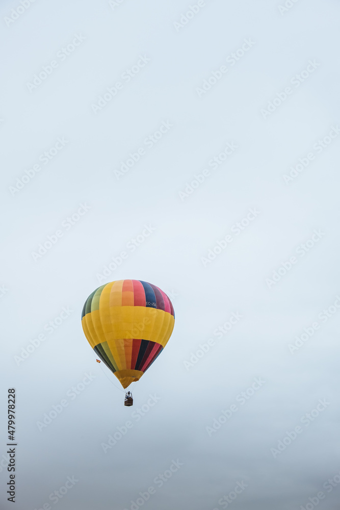 Colorful hot air balloon flying on a cloudy winter day Colorful hot air balloon flying on a cloudy winter day