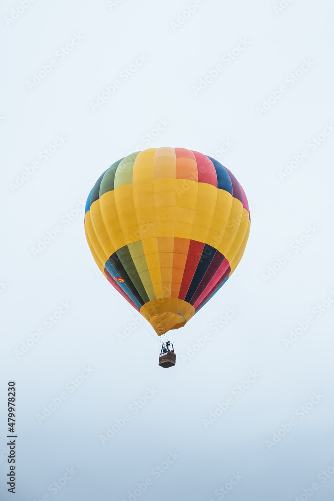Naklejka premium Colorful hot air balloon flying on a cloudy day