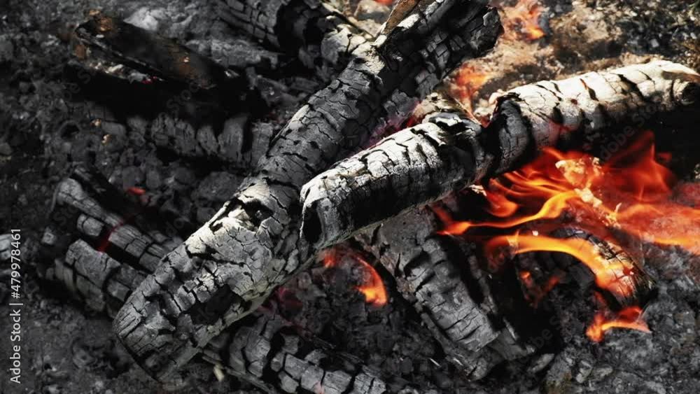 Sparking bonfire. Camping leisure. Travel activity. Macro closeup of campfire with red orange fire flame flowing smoke on pile of burning wood background. Sparking bonfire. Camping leisure. Travel activity. Macro closeup of campfire with red orange fire flame flowing smoke on pile of burning wood background.