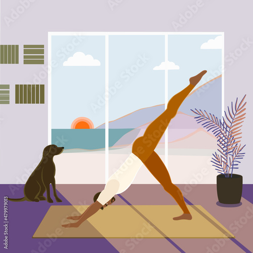 African American man working out indoors, standing in the one-legged downward facing dog or Eka Pada Mukha Svanasana pose in the early morning