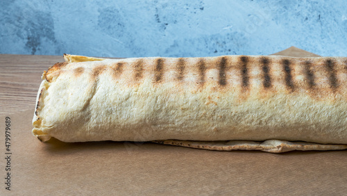 Shawarma chicken roll. Fresh roll of thin lavash or pita bread filled with grilled meat, cheese, carrots, sauce, green.