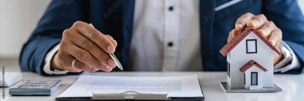 The real estate agent describes the home and materials and the client is discussing a home purchase contract, insurance or real estate loan.