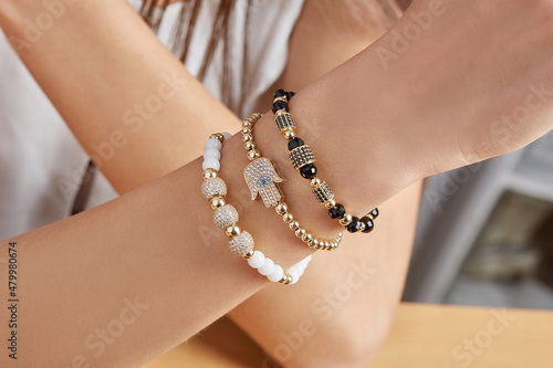 Bracelets. Unisex gold bracelet on woman hand © kamil