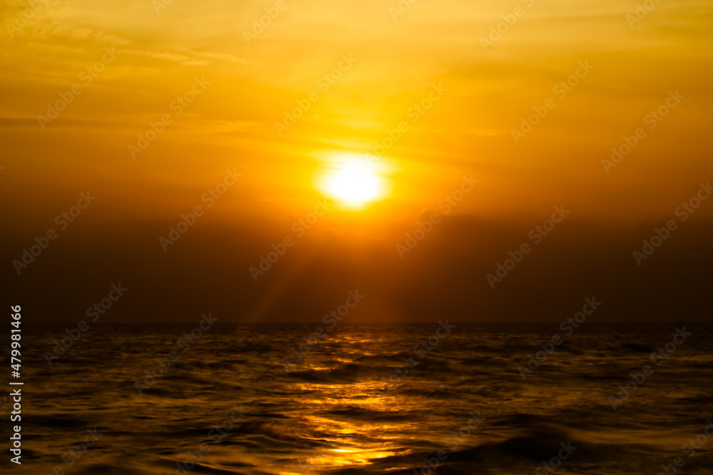 Beautiful long exposure of amazing sunset with silhouette smooth wavy sea and cloud. orange horizon with sunset sky.