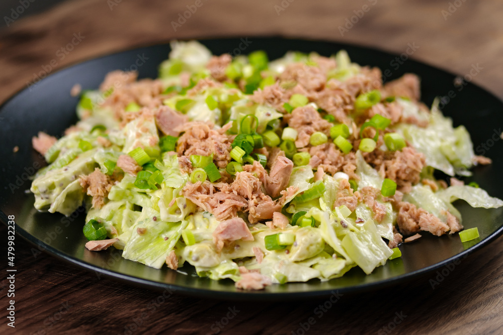 Tuna Salad with Lettuce, spring onions and dijon mustard salad dressing served on black plate Tuna Salad with Lettuce, spring onions and dijon mustard salad dressing served on black plate