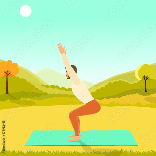 Fit man practicing yoga outside, standing in utkatasana or chair posture on the mat in the open air with a mountain view