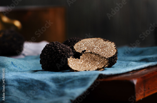Billede på lærred Cut black truffles on dark brown vintage background
