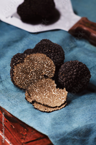 Billede på lærred Cut black truffles on dark brown vintage background