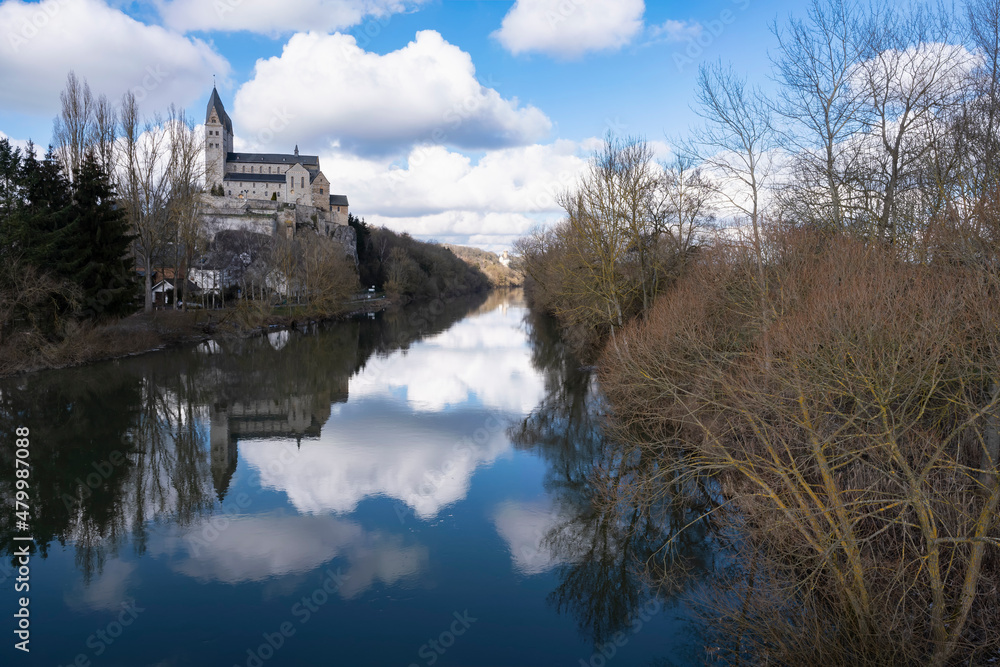 View of the St. Lubentius Basilica with reflection in the Lahn in Dietkirchen / Germany View of the St. Lubentius Basilica with reflection in the Lahn in Dietkirchen / Germany