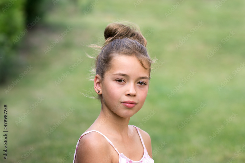 Outdoot portrait of a pretty girl in natural light isolated on green background. Annoyed teenager expression. Outdoot portrait of a pretty girl in natural light isolated on green background. Annoyed teenager expression.