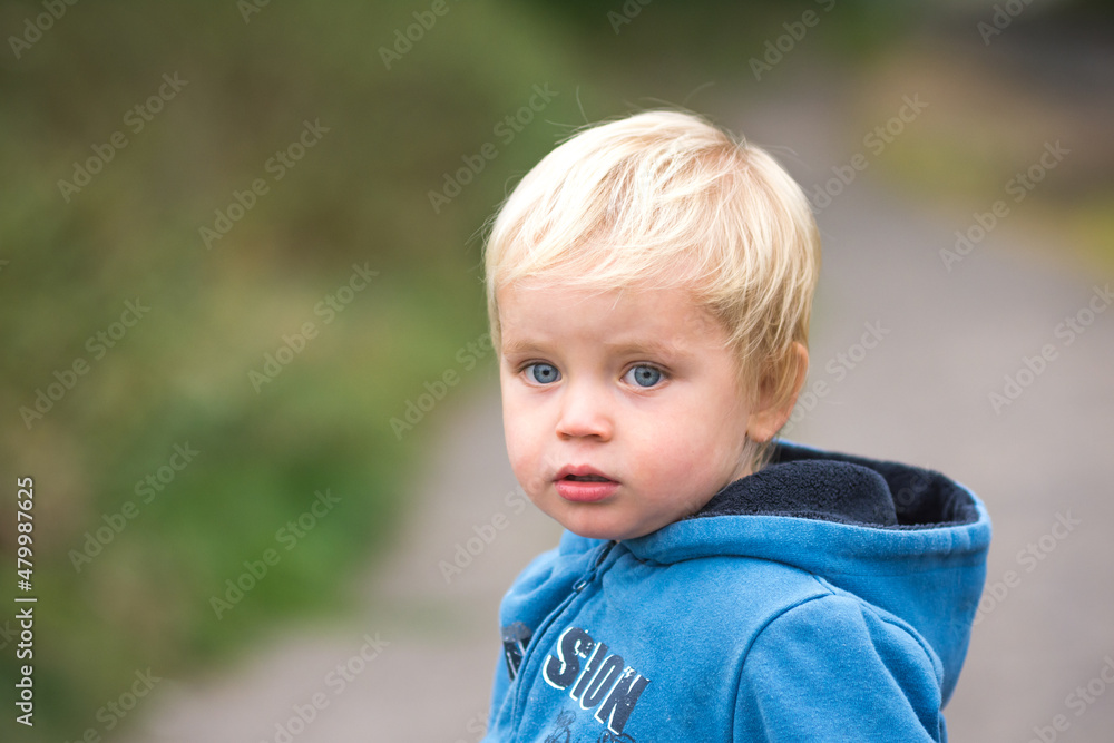 Portrait of a little caucasian child. Smiling small blond kid with blue eyes. Portrait of a little caucasian child. Smiling small blond kid with blue eyes.