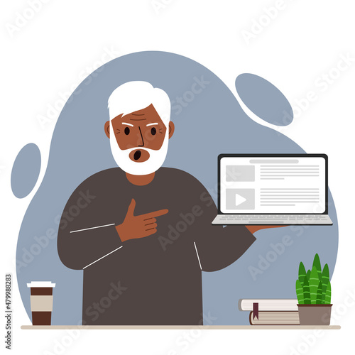 Screaming grandfather holding a laptop computer with one hand and pointing at it with the other. Laptop computer technology concept.