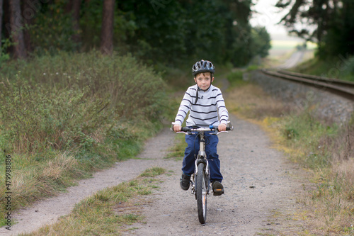 Fototapeta Naklejka Na Ścianę i Meble -  Little caucasian boy ride a bike. Safe sport with helmet protection.