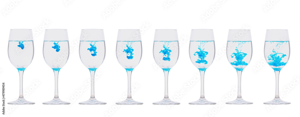 Blue ink dripping into a glass of water Blue ink dripping into a glass of water
