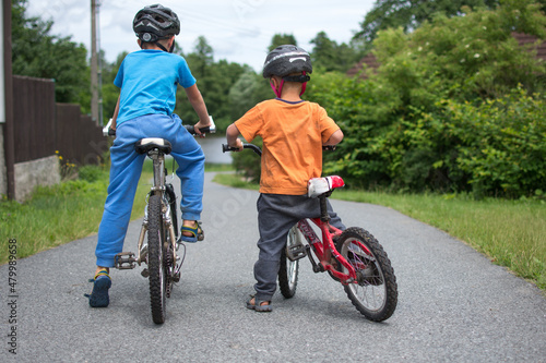 Fototapeta Naklejka Na Ścianę i Meble -  Two little boys with bicycle. Young Ciclist ride a bike