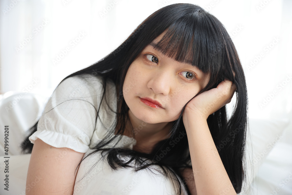 Beautiful young Asian woman sleeping on bed relaxing in the morning light with white room Beautiful young Asian woman sleeping on bed relaxing in the morning light with white room