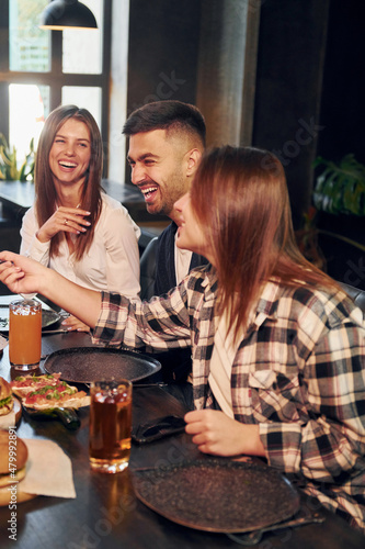 Positive emotions. Group of young friends sitting together in bar with beer