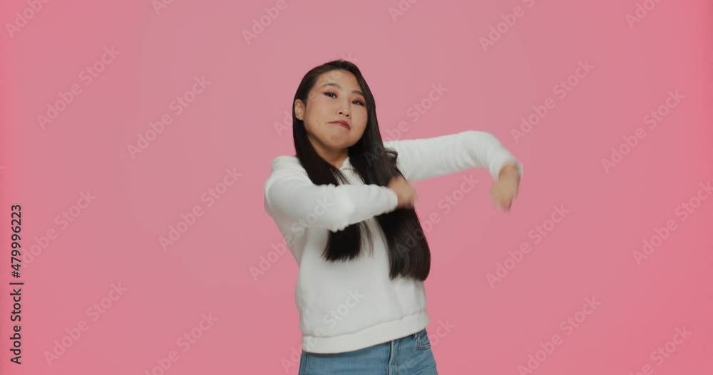 Dancing joyful young asian girl funny move in win dance having fun, enjoying music, celebrate success on pink background Dancing joyful young asian girl funny move in win dance having fun, enjoying music, celebrate success on pink background