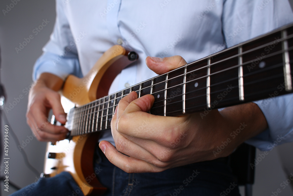 Male hands are playing a wooden six mstring guitar