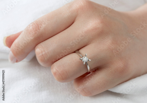 Jewelry background. Diamond ring on woman hand