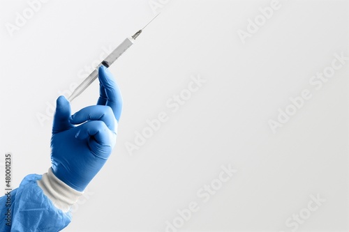 A doctor holds vaccine against new covid-19 omicron variant on a background photo