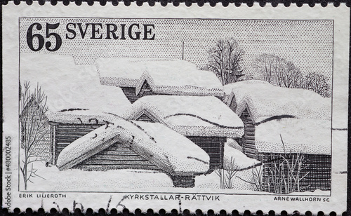 Sweden - circa 1973: a postage stamp from Sweden historic wooden houses in the snow in the Swedish province of Dalecarlia photo