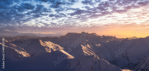 Aerial Panoramic View of Canadian Mountain covered in snow. Winter Sunset Sky Art Render. Located near Whistler, North of Vancouver, British Columbia, Canada. Nature Background Panorama