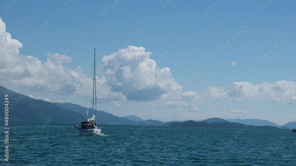Yacht with lowered canvas drifts under sky with clouds Yacht with lowered canvas drifts under sky with clouds