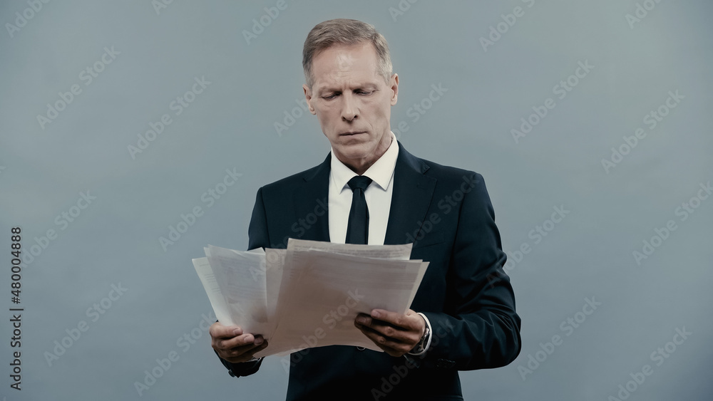 Mature manager holding documents isolated on grey. Mature manager holding documents isolated on grey.