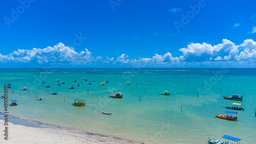 Praia com piscinas naturais e água cristalina vista de drone