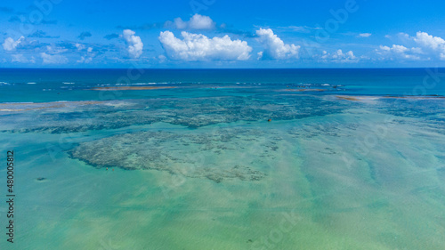 Praia com piscinas naturais e   gua cristalina vista de drone