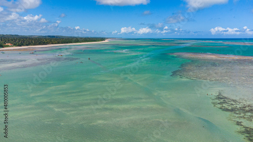 Praia com piscinas naturais e água cristalina vista de drone
