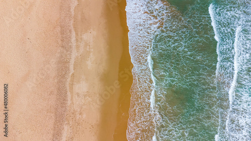 praia com águas cristalinas e ondas vista de drone