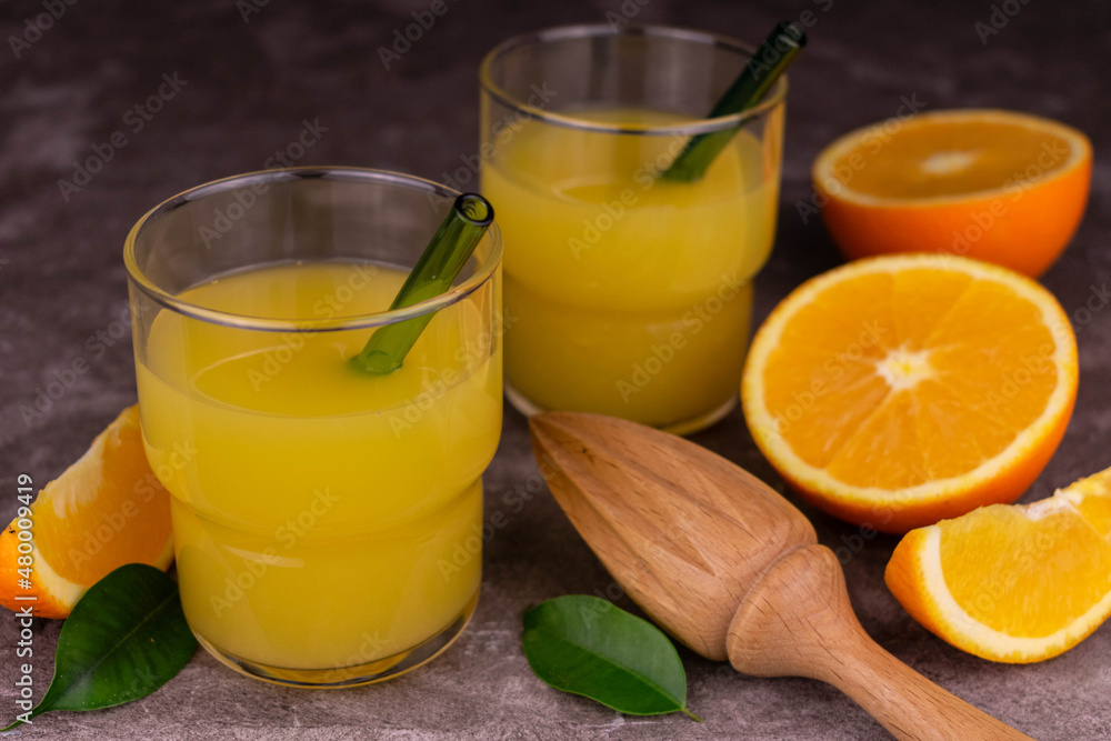 Fototapeta premium Fresh orange juice on a gray background.