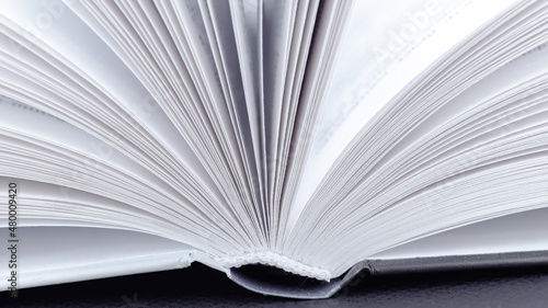 Book spine macro photography. Open book with white pages close-up with copy space. The concept of visiting libraries and reading various books, encyclopedias. Sustainable education concept.