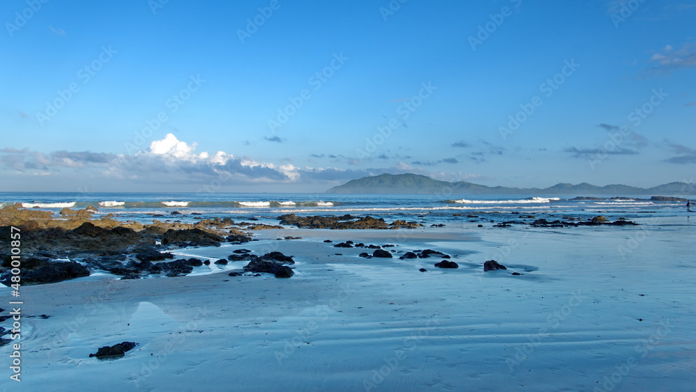 Rugged beach with mountains in the background in Tamarindo, Costa Rica