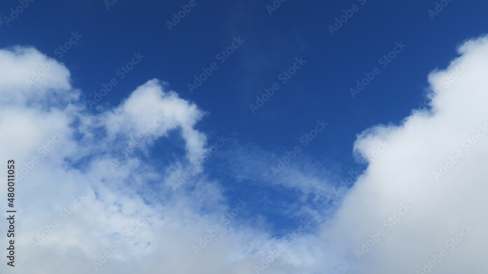 White cloud field with interesting shapes in the blue sky on a sunny day with space for a message