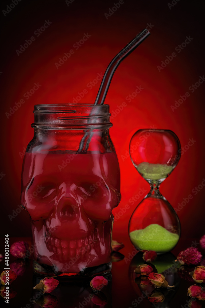 Red juice in skull jars on a red background.