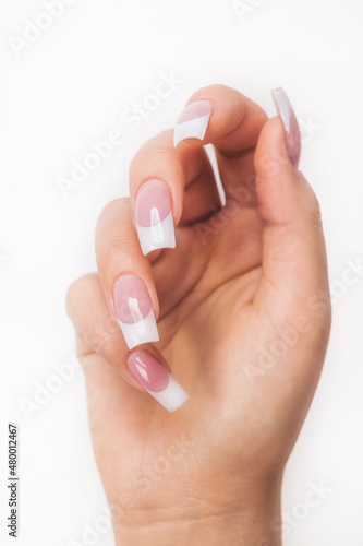 Wypielęgnowana dłoń z manicure na białym tle