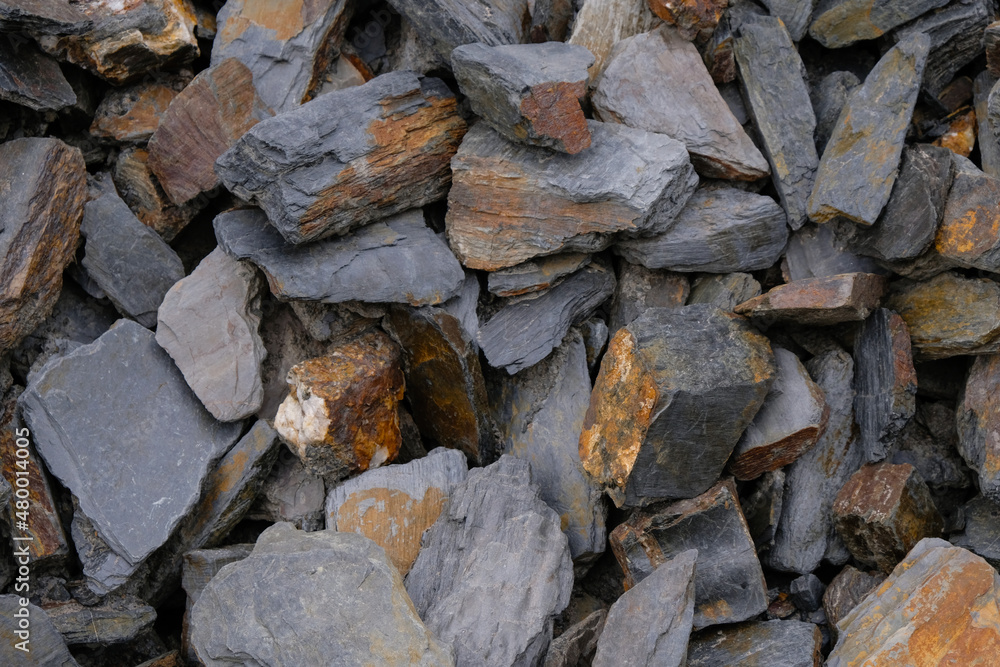 Slate stone for design. Dark gray stones with rusty spots. Slate stone for design. Dark gray stones with rusty spots.