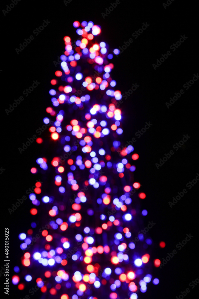 Blurry indistinct image of multicolored holiday lights at night. Blurry indistinct image of multicolored holiday lights at night.